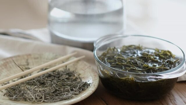 Dry and soaked seaweed on a wooden table. Preparing of laminaria salad