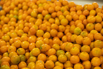 Closeup pile of fresh ripe juicy tangerines with glossy orange skin. Rich harvest of organic vitaminic citrus. Fruit benefit concept. Natural food background.. © JackF