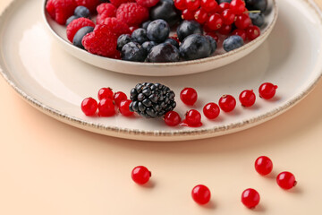 Plate with fresh berries on color background, closeup