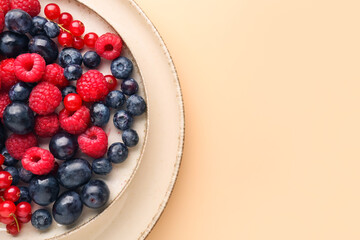 Plate with fresh berries on color background, closeup