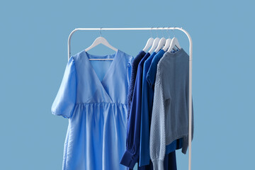 Rack with blue clothes near color wall