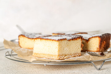 Grid with pieces of tasty cottage cheese casserole on light background, closeup