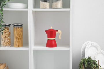 Geyser coffee maker and groceries on shelf in kitchen