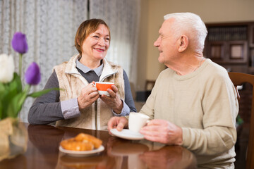 Fototapeta na wymiar Portrait of senior couple drinking tea together at living room.