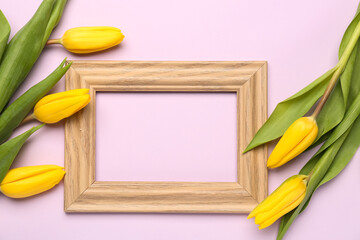 Composition with empty picture frame and yellow tulip flowers on pink background. Hello spring