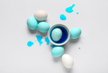 Beautiful Easter eggs and bowl of dye on white background