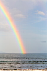 A rainbow on blue sky over endless water