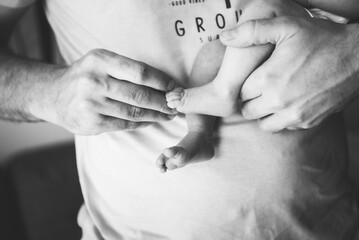 close up of a man holding his babies feet