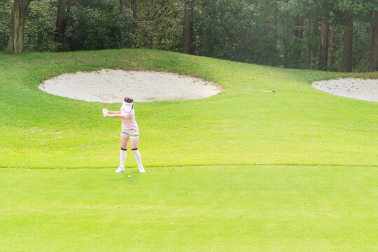 ゴルフをする若い女性