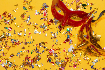 two colorful carnival masks on the yellow background with several ornaments