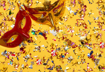 two colorful carnival masks on the yellow background with several ornaments