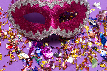 colorful carnival mask on the pink background with several ornaments