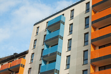 facade of the building with multi-colored balconies against the blue sky