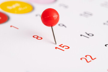 Embroidered red pins on a calendar on the 15th with selective focus