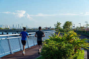 couple doing sports in cinta costera, with the skyline behind panama city