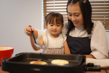 ホットケーキを焼く親子
