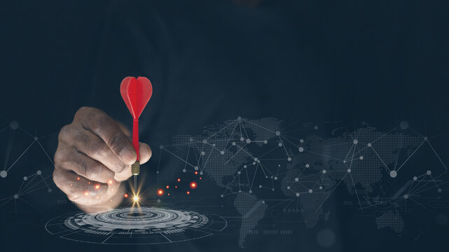 Businessman holding red darts with virtual screen dart board .targeting the business concept