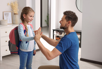 Obraz premium Happy father giving high five to his daughter at home. Preparing to school