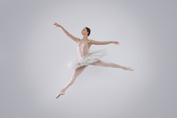 Fototapeta na wymiar Young ballerina practicing dance moves on white background