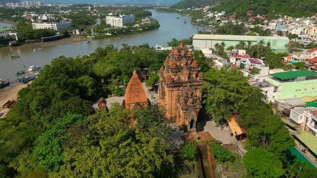 Tower against the backdrop of tall pagoda and blue sky. Aerial view of the Ponagar Tower on Mount La Lao of Vietnam is one of Vietnam landmarks in Nha Trang. Tourists take pictures on backdrop Ponagar
