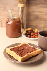 Tasty toast with chocolate paste and cup of tea served on light table