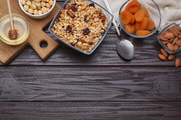 Tasty granola with nuts and dry fruits on wooden table, flat lay. Space for text