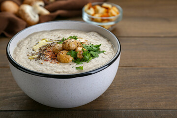 Delicious cream soup with mushrooms on wooden table