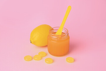 Cough drops, fresh orange and honey on pink background