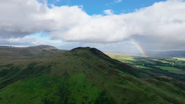 Aerial Angle Lifting up to Reveal Conic Hill Located Next to Loch Lomond, Scotland. Beautiful Rainbow in the Distance