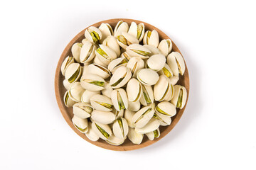 Pistachio nuts in wooden plate isolated on white background. 