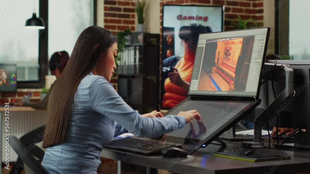 Poster asian game developer working in production department to create professional content, using touchscr