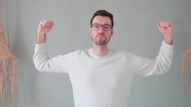 Hipster flexes with muscles, biceps showing, muscle posing although actually untrained, no muscular man training fitness concept