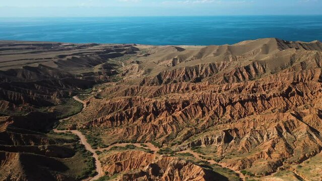 Wide drone shot of Fairy Tale Canyon and Issyk-Kul Lake in Karakol, Kyrgyzstan