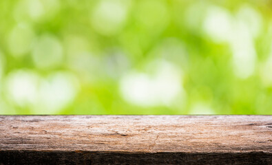 Fototapeta premium wooden floor with bokeh blur of nature park background and summer for your display montages