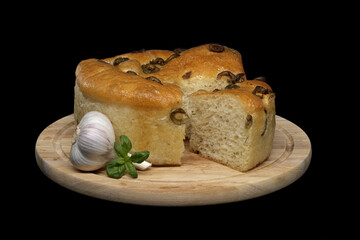 Focaccia bread with olives on black background