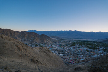 Leh town seen from above with many houses and mountains surrounded at Ladakh, in the Indian Himalayas.