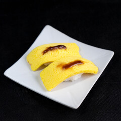 Egg sushi or tamako sushi, Japanese food with black background.