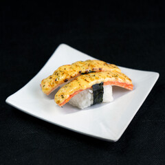 sushi with mentai sauce on a black background