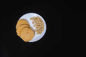 indian traditional sweet tilkut in white plate with black background