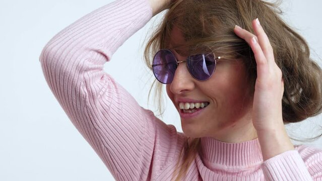 Portrait of a young pretty cheerful, thoughtful woman with a playful look, purple glasses and messy hair. European beautiful brunette woman . White background