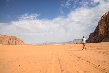 mężczyzna idący po pustyni - obrazy, fototapety, plakaty
