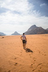 mężczyzna idący po pustyni - obrazy, fototapety, plakaty