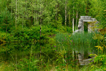 Decorative ruins near a forest lake
