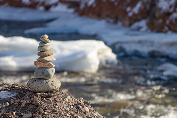 Fototapeta na wymiar Rocks stack on the coast of winter Mountain River, concept of balance and harmony.