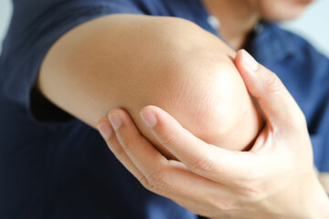 man touching the elbow with elbow pain And he relieves pain with massage. Health and healing...