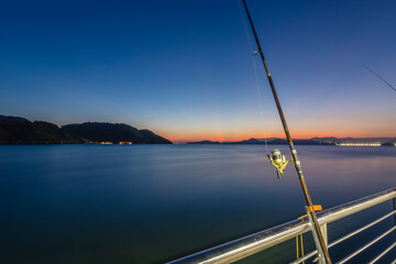 Fishing rod. Colorful sunset on the fisherman's deck in the city of Santos, Brazil. 