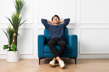 portrait of asian man sitting on sofa at home
