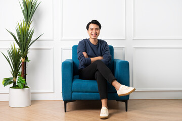 portrait of asian man sitting on sofa at home
