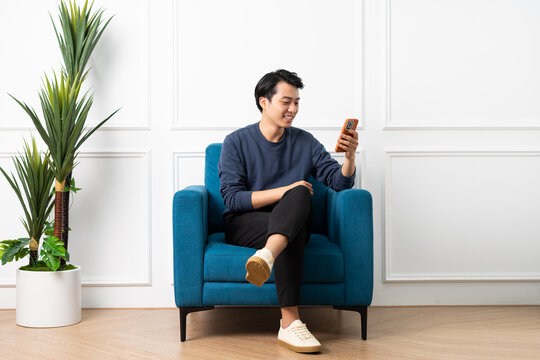 portrait of asian man sitting on sofa at home
