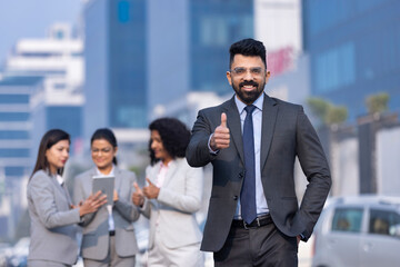 Portrait satisfied businessman showing to camera thumbs up